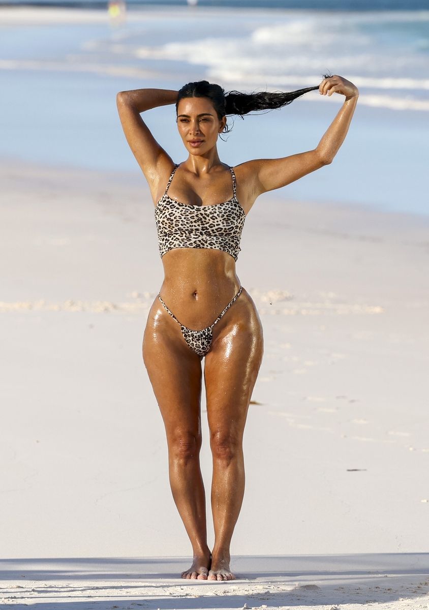 Kim Kardashian strikes a pose while wearing a sexy leopard-print bikini enjoying a beachside photoshoot. 