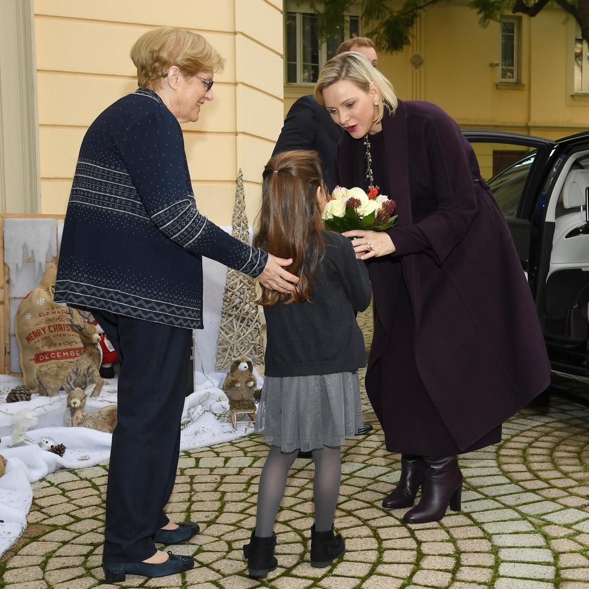 Princess Charlene receives flowers from a little girl