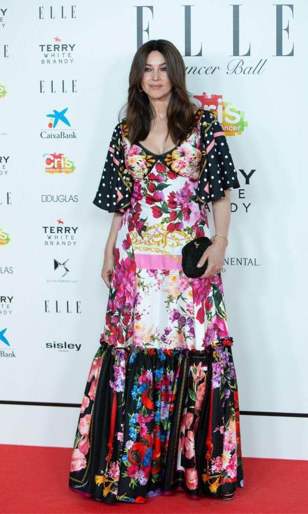 Monica Bellucci wearing a long patchwork dress featuring floral and polka dot patterns
