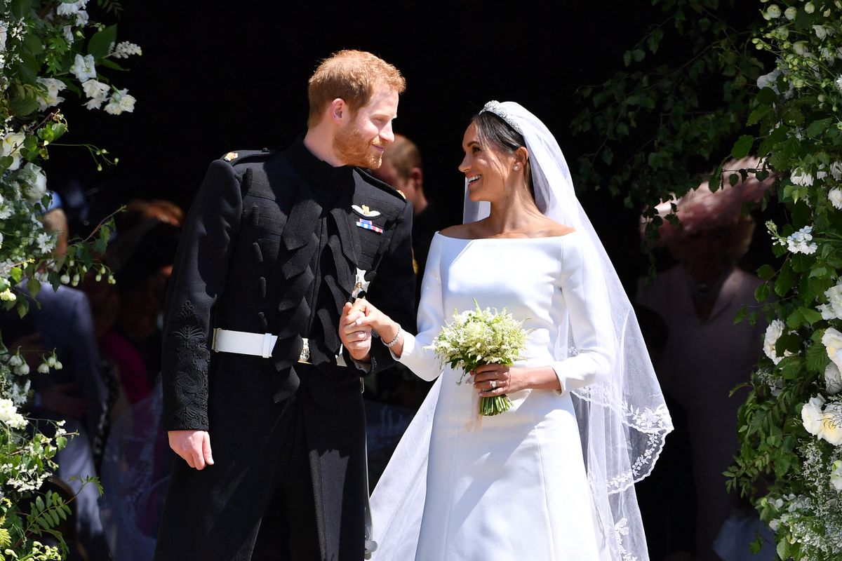 TOPSHOT - Britain's Prince Harry, Duke of Sussex and his wife Meghan, Duchess of Sussex emerge from the West Door of St George's Chapel, Windsor Castle, in Windsor, on May 19, 2018 after their wedding ceremony. (Photo by Ben STANSALL / various sources / AFP) (Photo by BEN STANSALL/POOL/AFP/AFP via Getty Images)