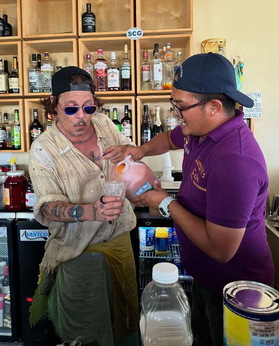 Johnny Depp has fun  with bartender Ralf Zoilo - AKA "Killer Bartender" - as he enjoys a cocktail at High Tide Cafe in The Bahamas on August 28.