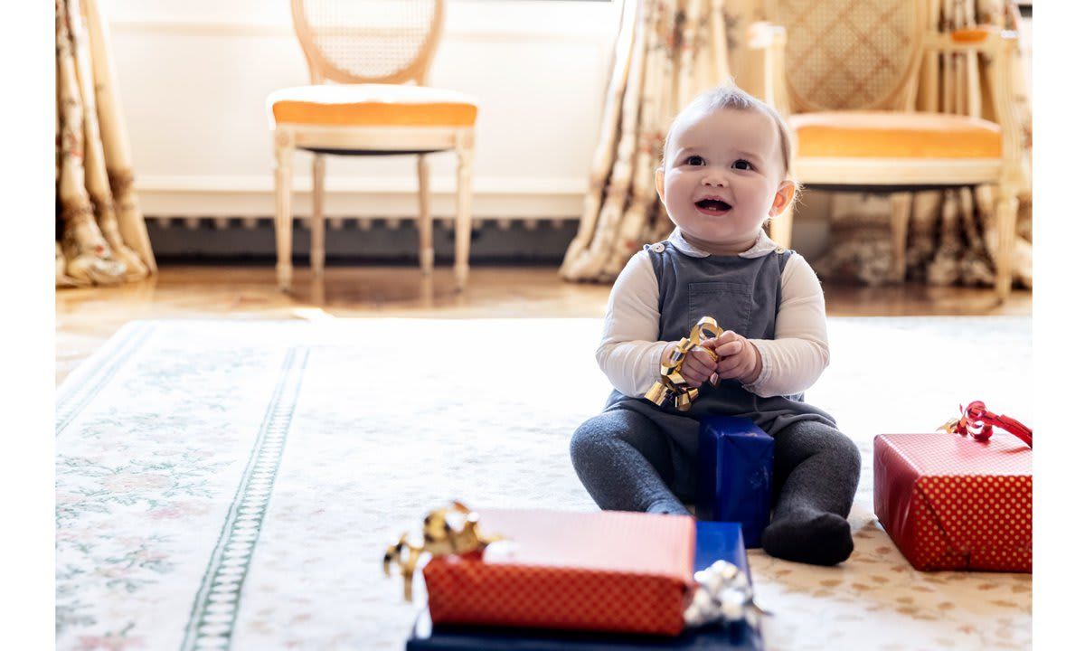 The birthday boy played with a curly ribbon bow while surrounded by presents in another shot.