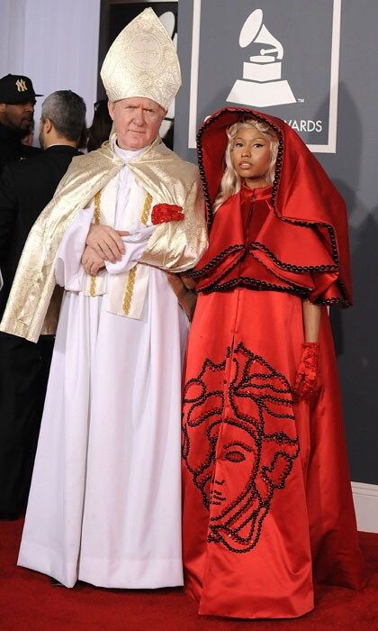 Nicki Minaj caused a stir at 2012's Grammy ceremony when she arrived in an unusual voluminous red cape, accompanied by a man dressed as the Pope. Nicki's scarlet outfit, complete with satin gloves, bore Versace's logo in black beads for all to see. <br>Photo: Getty Images