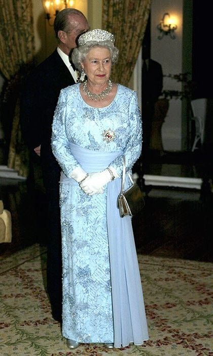 The Queen attended the second day of her official tour of Jamaica in 2002 wearing a blue embroidered dress with silk sash.
<br>
Photo: Getty Images