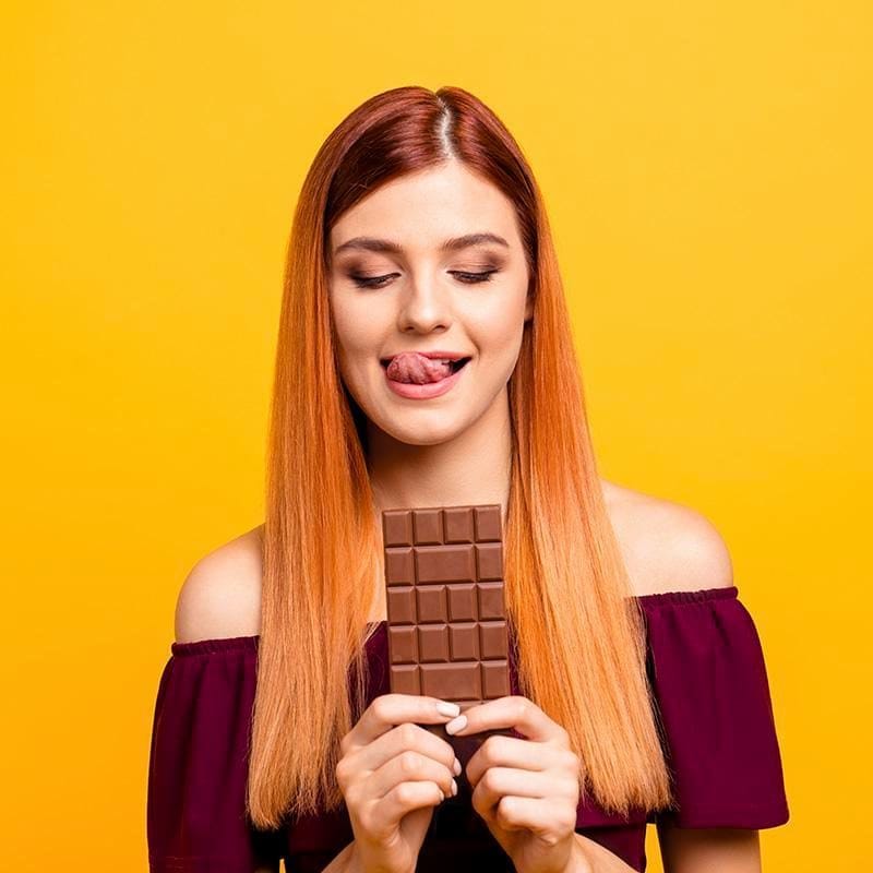 Woman eating a bar of chocolate