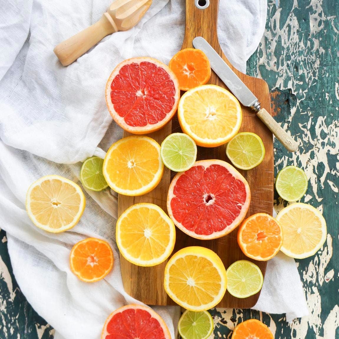 Mixed citrus fruit halves on a chopping board