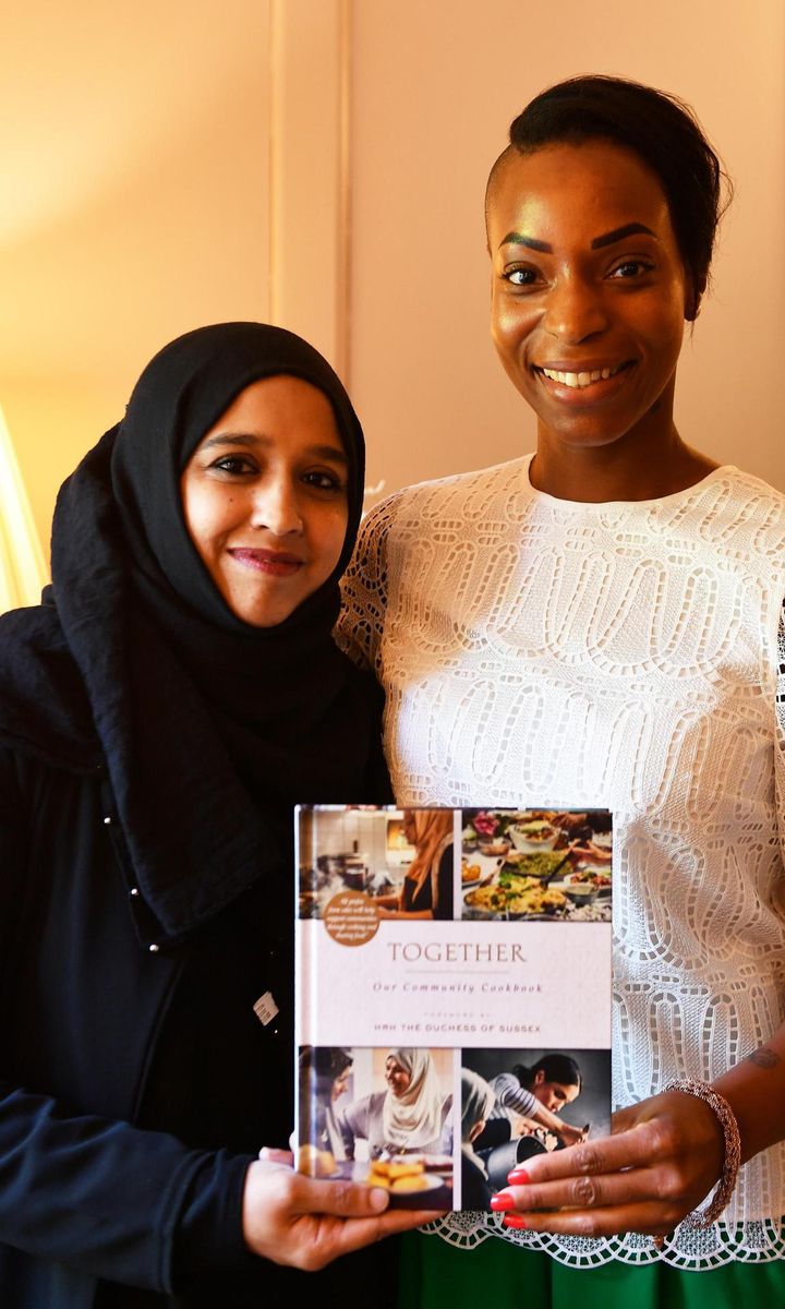 Meghan Markle top aid Natalie Campbell with a member of Hubb Kitchen posing with cookbook Together