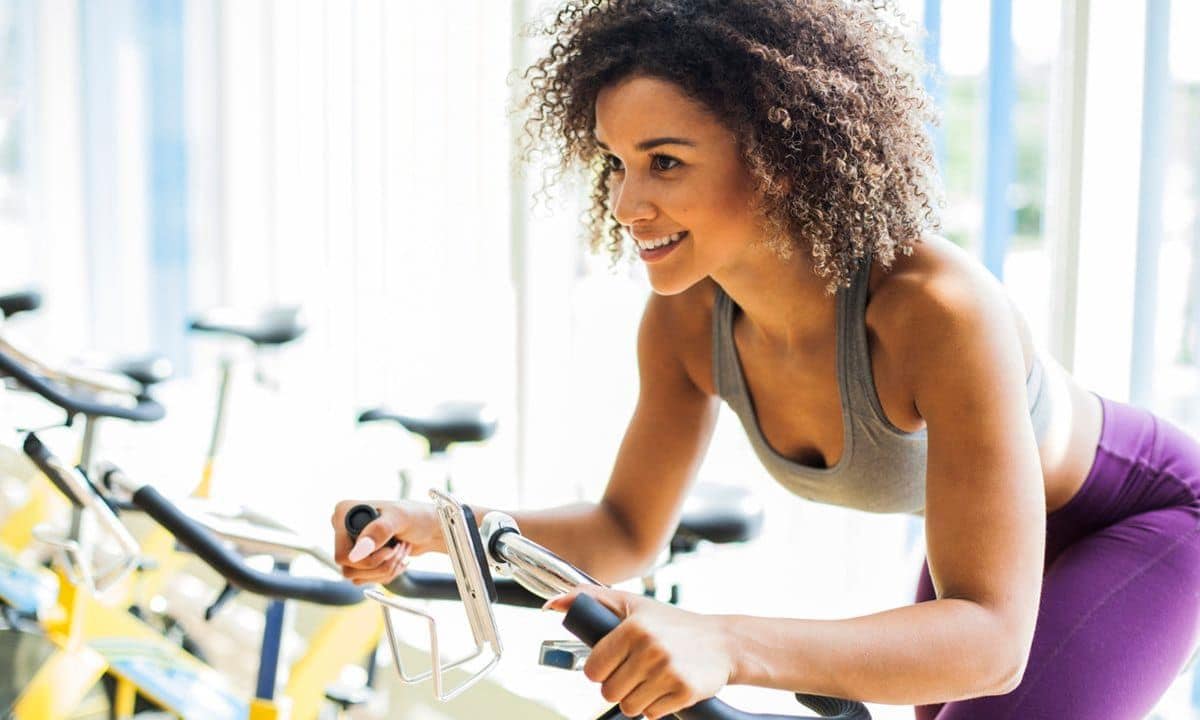 Woman Doing Cardio Exercises on a Stationary Bike at the Gym