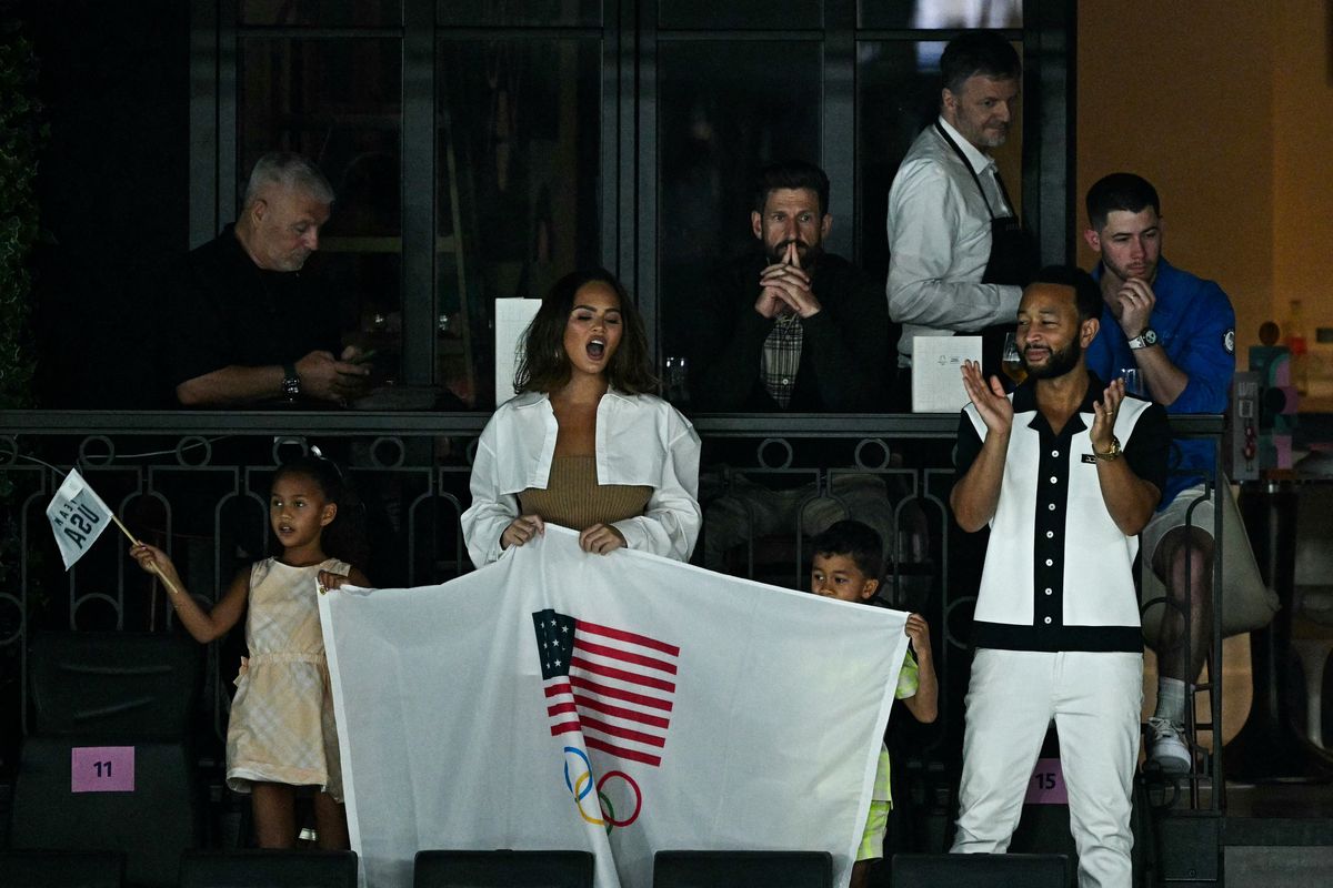 US model Chrissy Teigen (2L) and her husband, US singer John Legend (R), attend the artistic gymnastics women's qualification during the Paris 2024 Olympic Games at the Bercy Arena in Paris on July 28, 2024. (Photo by Gabriel BOUYS / AFP) (Photo by GABRIEL BOUYS/AFP via Getty Images)