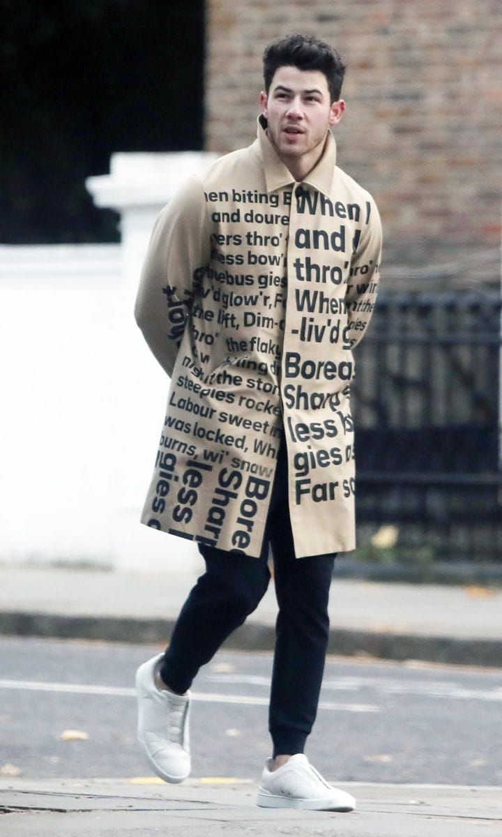 Nick Jonas in an Eye-Catching Word Print Coat Enjoys a Walk in London