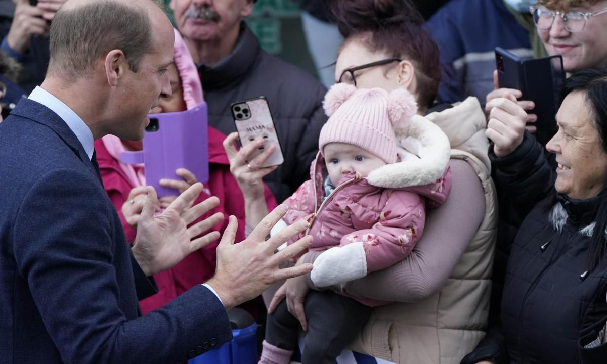 The heir to the British throne greeted a baby while in Holyhead.