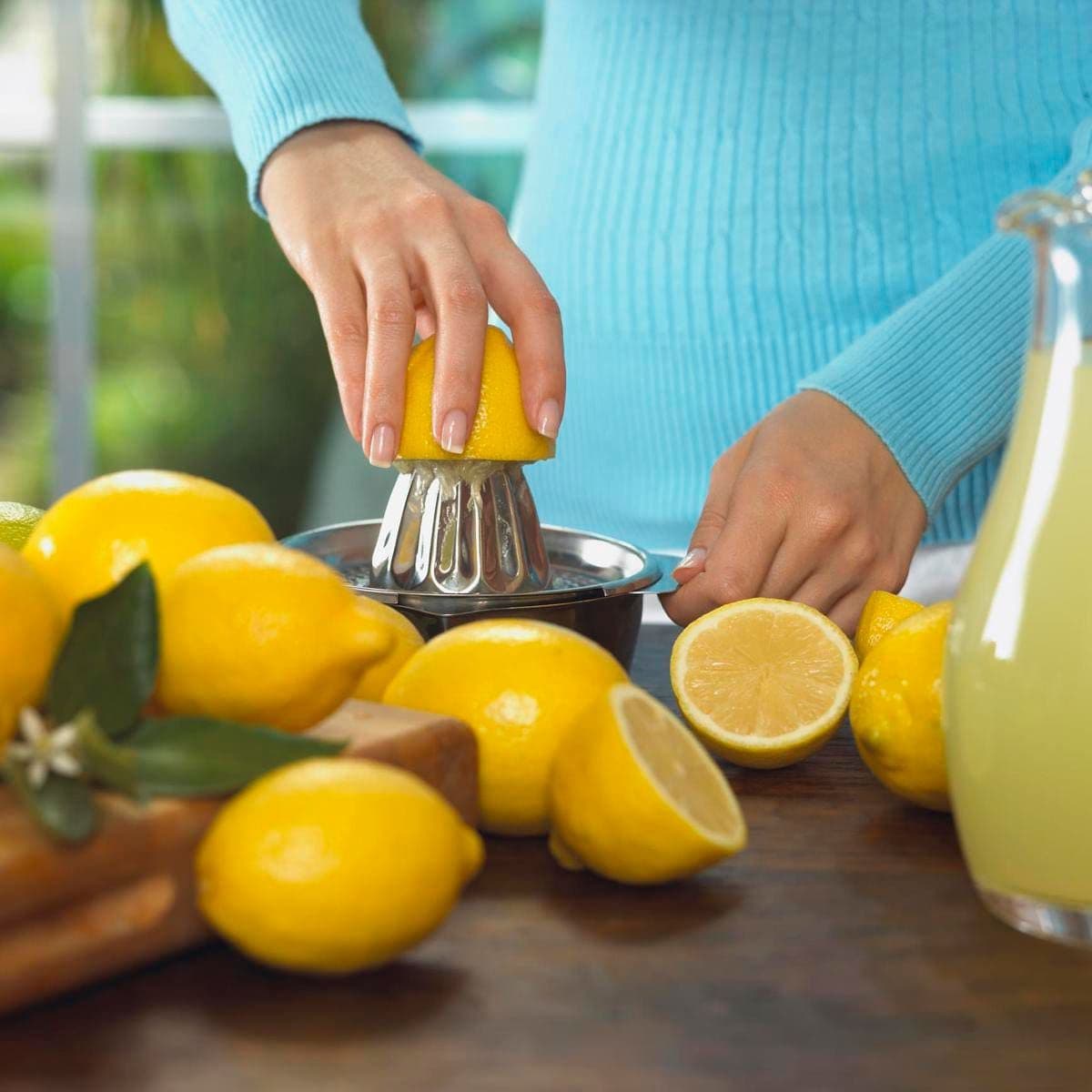 Woman squeezing lemons into lemonade