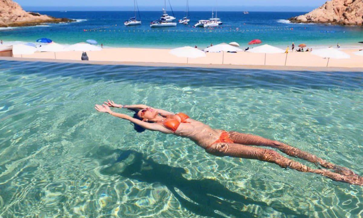Alessandra Ambrosio models a string bikini while splashing around in a pool in Mexico