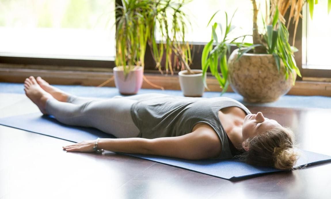 Woman in Shavasana on a yoga mat