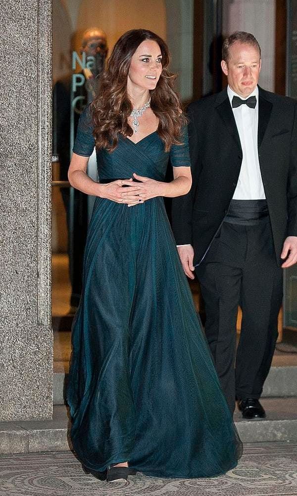 Kate Middleton in a dark green dress with a crossed body and black velvet belt