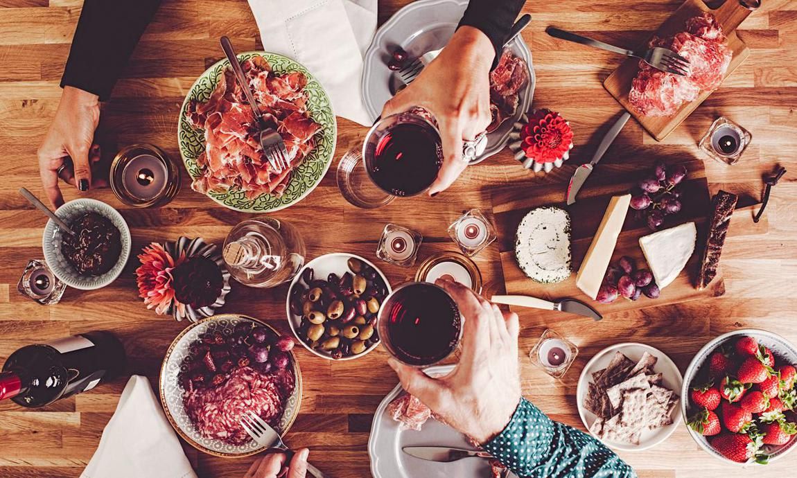 Mesa con diferentes platos y copas de vino