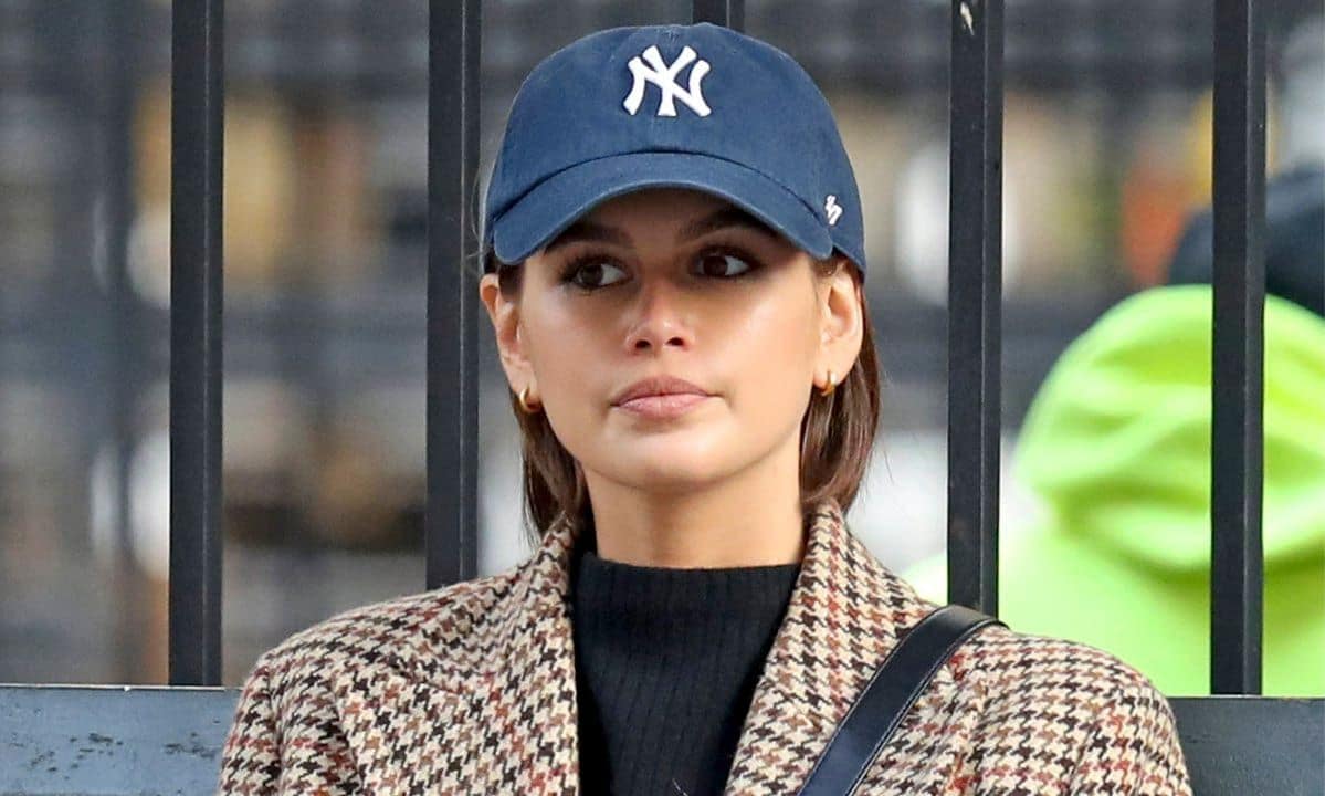 Model Kaia Gerber wears a brown tweed coat, jeans and converse sneakers, NYC.