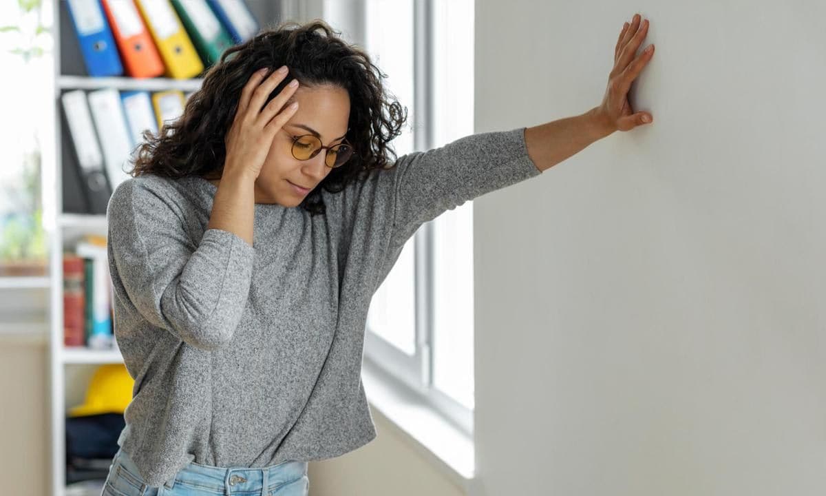 Woman suffering from dizziness with difficulty standing up