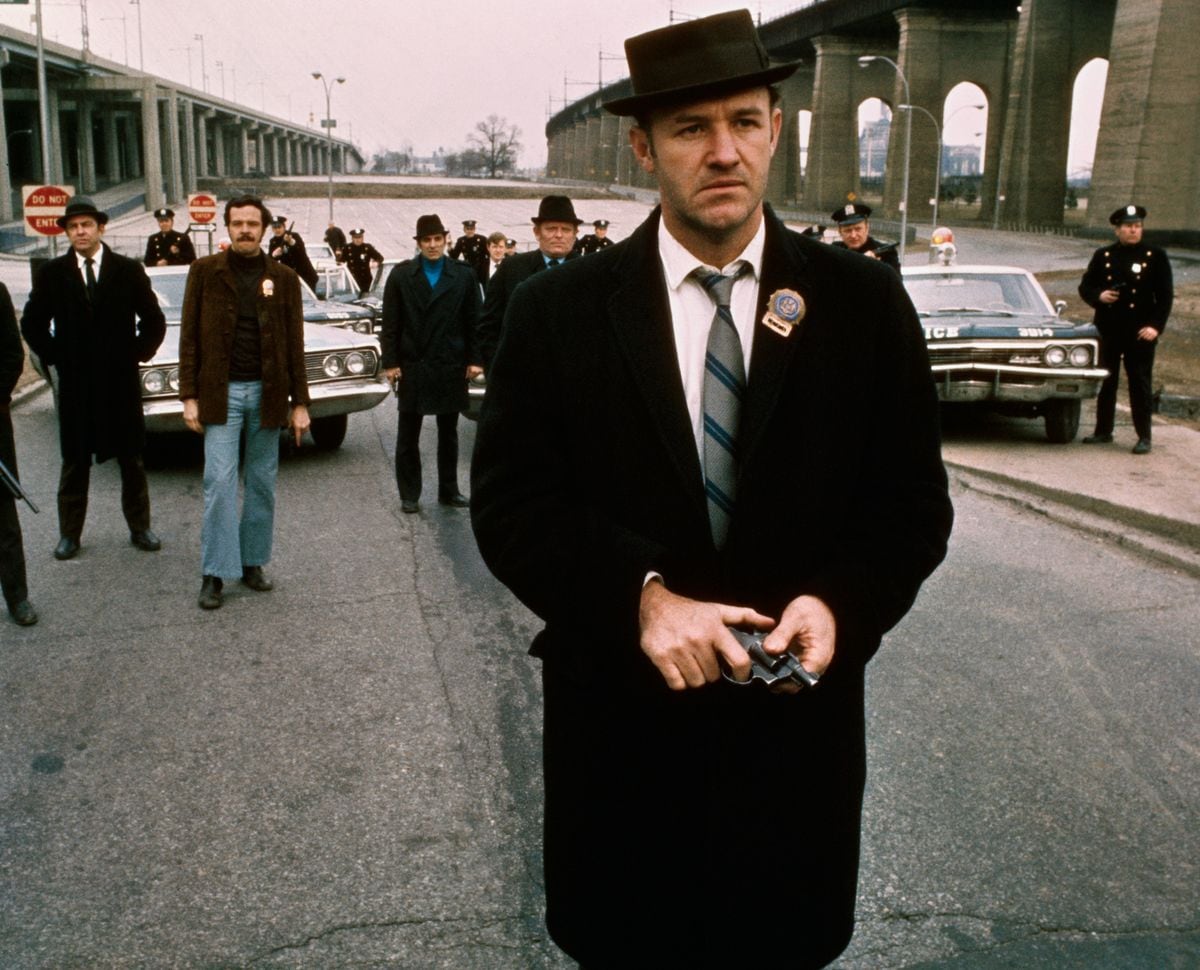 Policeman Gene Hackman is shown in this movie still walking toward the camera. He is holding a gun in his hands with policemen and police vehicles in the background. It was in this movie The French Connection that Gene Hackman won "Best Actor." The movie itself won "Best Picture."