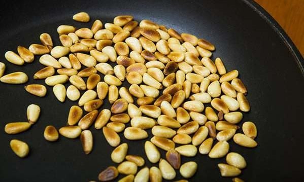 Pine nuts toasted in a frying pan