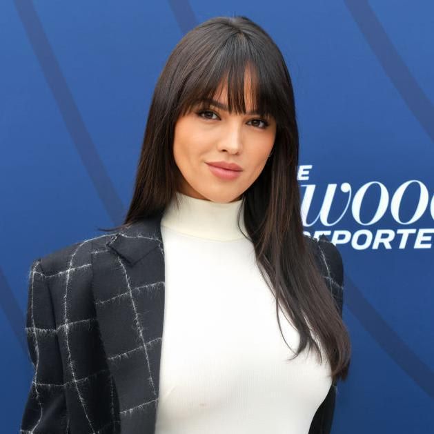 Eiza Gonzalez in a suit, a white turtleneck, and dark hair with a fringe