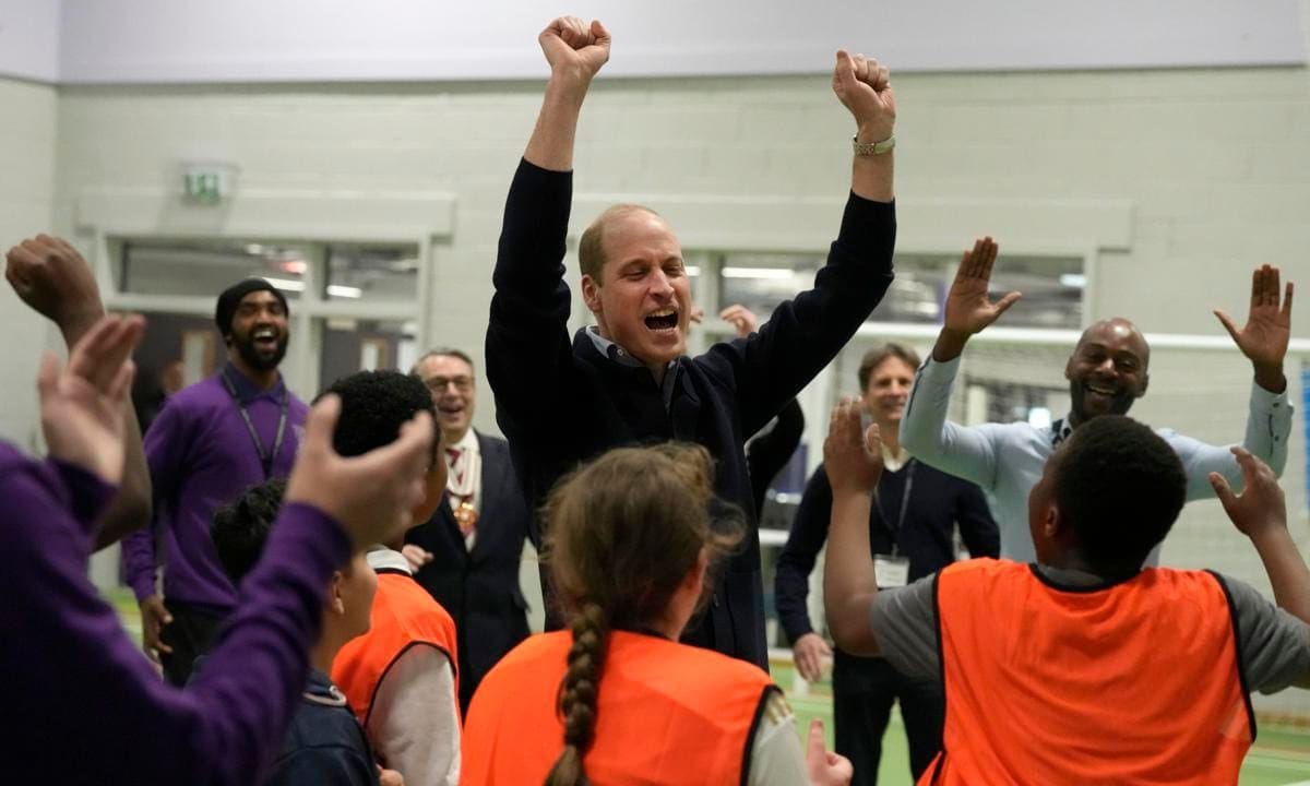 The Prince of Wales pictured cheering with youngsters after throwing a basketball