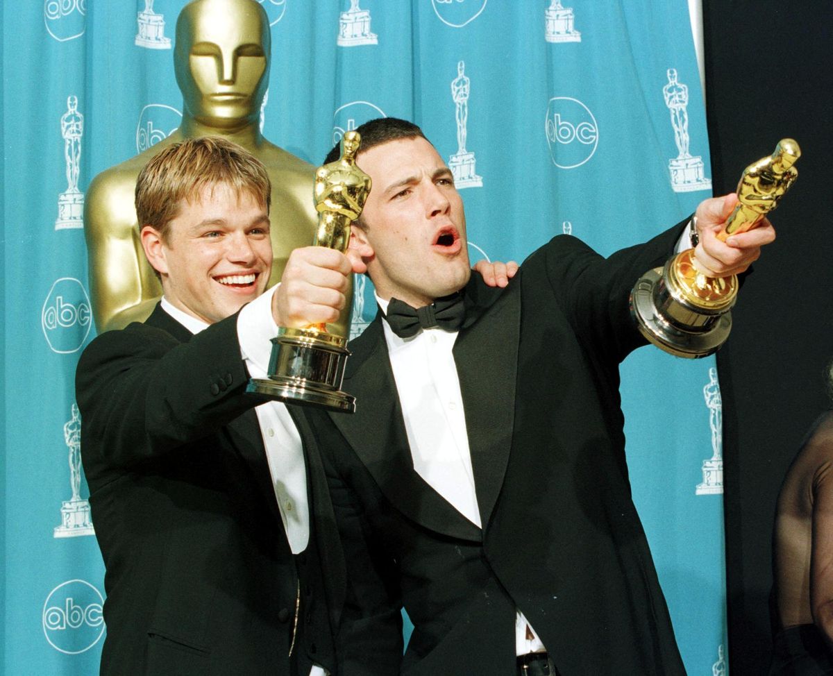 Matt Damon and Ben Affleck hold the awards they won for best original screenplay for the film "Good Will Hunting" 