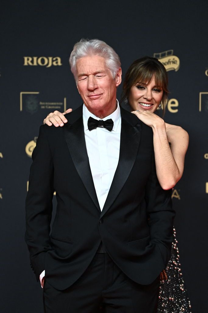 Richard Gere and Alejandra Silva pose at the 2025 Goya Awards red carpet, sharing a romantic and joyful moment.