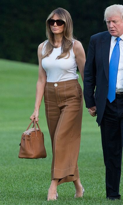 Melania Trump wore $575 wide-legged cropped Bally pants while moving into the White House. The First Lady kept her outfit simple with a white Dolce & Gabbana tank top and her signature oversized shades as she accompanied her husband, President Trump, and their 11-year-old son Barron to her new home. The former model whose chic wool trousers are now on sale on the Bally website for $460 completed her look with a stylish Hermes Birkin bag.
Photo: Chris Kleponis-Pool/Getty Images
