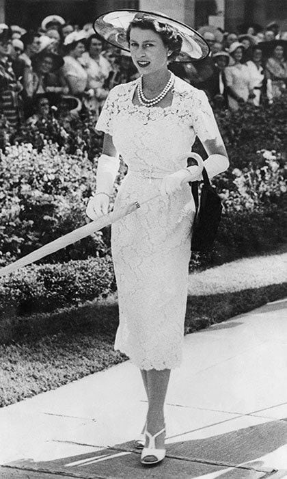 Queen Elizabeth wore a slim-fitting white lace dress to a garden party in Sydney, Australia, before leaving for Tasmania on the liner 'SS Gothic' in 1954.
<br>
Photo: Getty Images