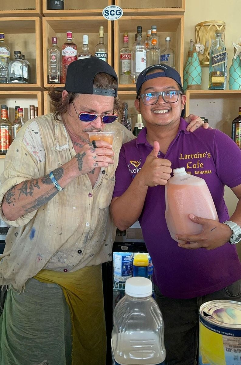 Johnny Depp has fun with bartender Ralf Zoilo - AKA "Killer Bartender" - as he enjoys a cocktail at High Tide Cafe in The Bahamas on August 28.