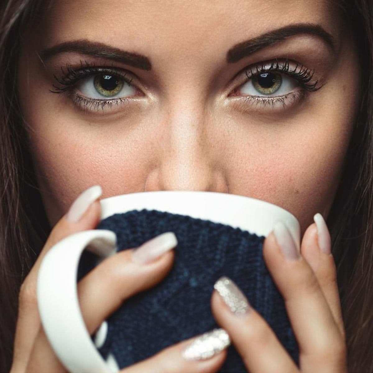 Mujer de ojos verdes toma cafe