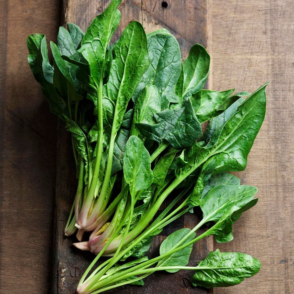 Fresh spinach leaves on a wooden surface