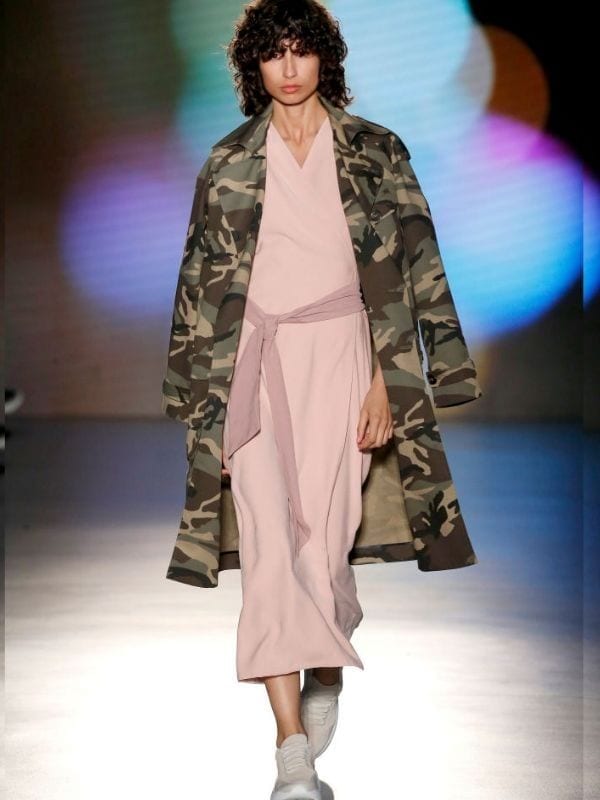 model wears camouflage print jacket on fashion catwalk