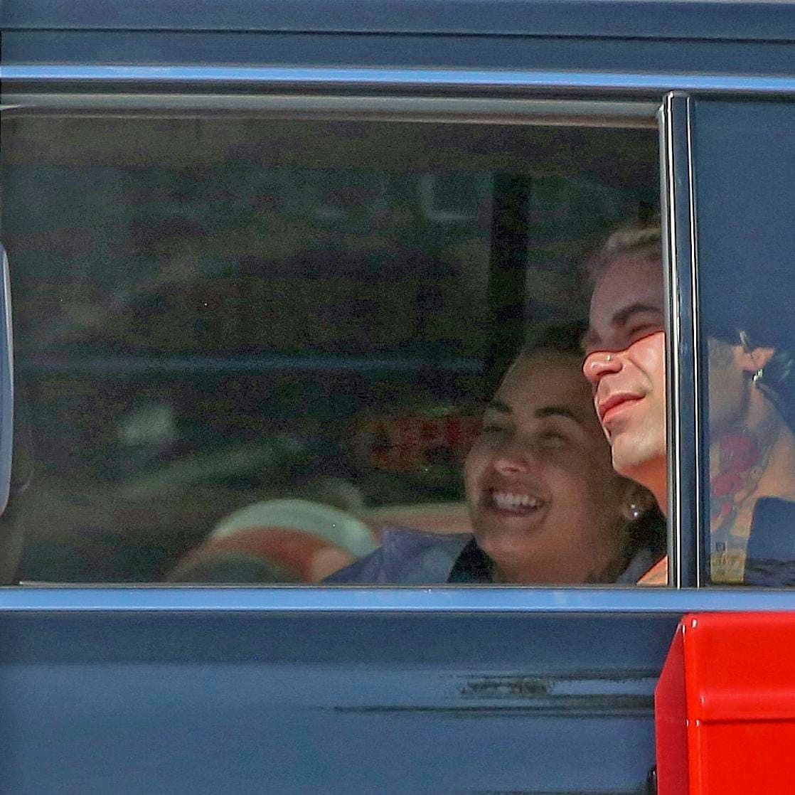 Demi Lovato giggles in the back seat of a SUV with Bella Thorns Ex Mod Sun.