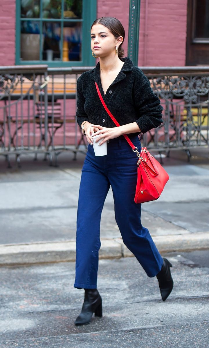 Selena wearing jeans and a red bag