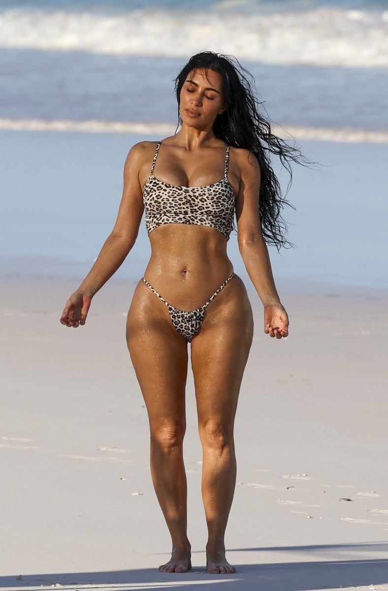 Kim Kardashian strikes a pose while wearing a sexy leopard-print bikini enjoying a beachside photoshoot. 