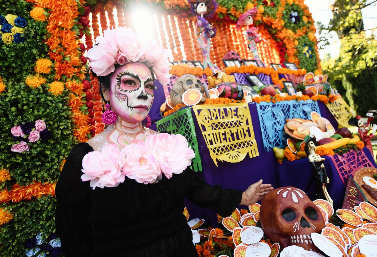 An attendee in costume poses at an altar during the Hollywood Forever Presents Dia De Los Muertos Celebration at Hollywood Forever on October 26, 2024 in Hollywood, California. (Photo by Chelsea Guglielmino/Getty Images)