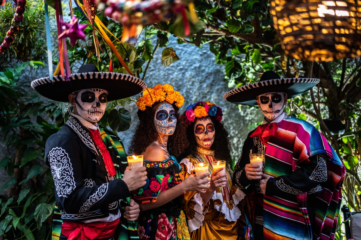 Portrait of a friends celebrating the day of the dead lighting candle