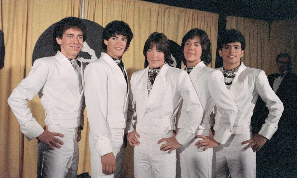 Ricky Melendez, Charlie Masso, Roy Rosello, Rey Reyes, and Robi Rosa of Menudo present award for “Best Recording for Children” at the 1984 Grammy Awards.