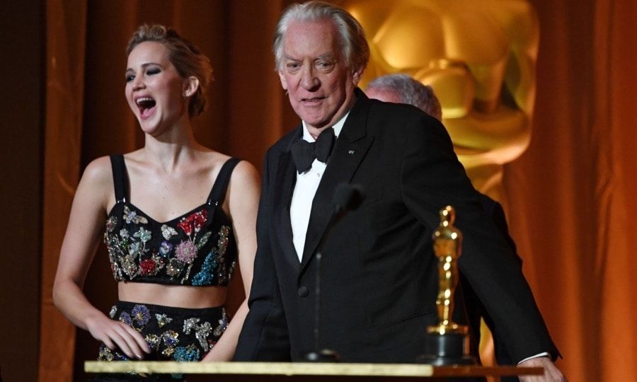 Once inside, Jennifer, who wore an intricate two-piece Alexander McQueen gown, presented an honorary Oscar to her <i>Hunger Games</i> co-star Donald Sutherland. Clearly, she was still giddy from all that photobombing!
Her smile was also due to the fact that her boyfriend was her date. Darren Aronofsky and Jennifer seemed to be in good spirits as they sat at the same table and enjoyed each other's company.
Photo: ROBYN BECK/AFP/Getty Images