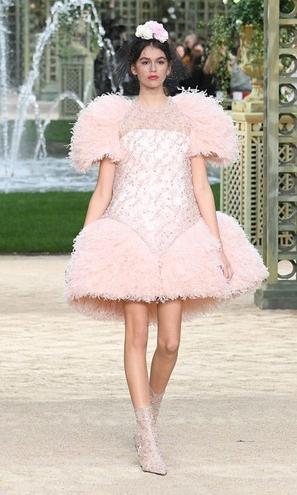 Kaia Gerber has been making quite the name for herself in the fashion world and on January 23, she had another runway milestone. Cindy Crawford and Rande Gerber's 16-year-old daughter walked her first Haute Couture show for Chanel at the Grand Palais.
Kaia, who previously walked in Chanel's show in Hamburg, Germany, was pretty in a pink structured dress and clear booties for the garden-themed presentation. To complement her look, her makeup also had pink undertones and a bright pink lip.
Photo: WireImage