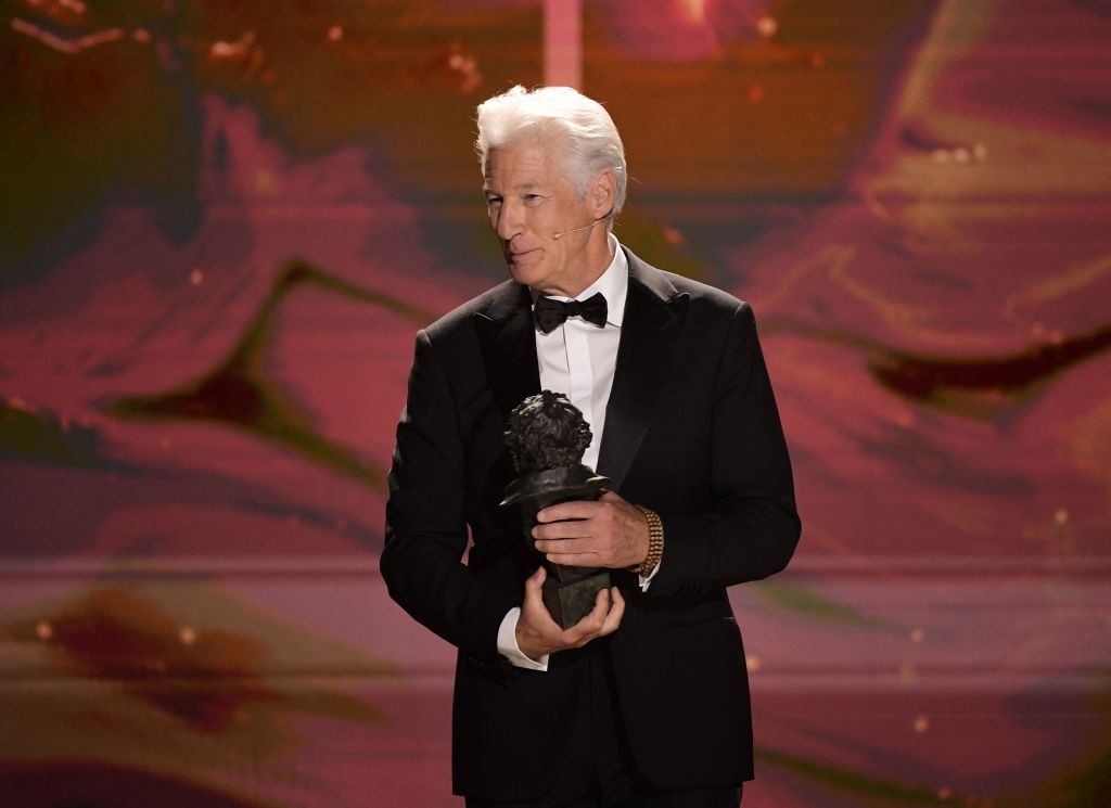    Richard Gere holding his Goya International Award on stage at the 2025 Goya Awards.