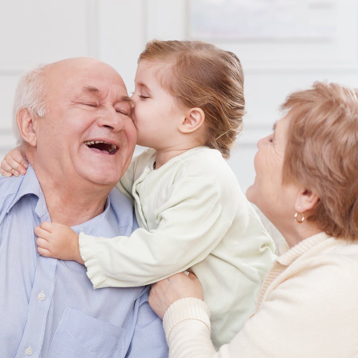 Cute small child is expressing love to grandparents
