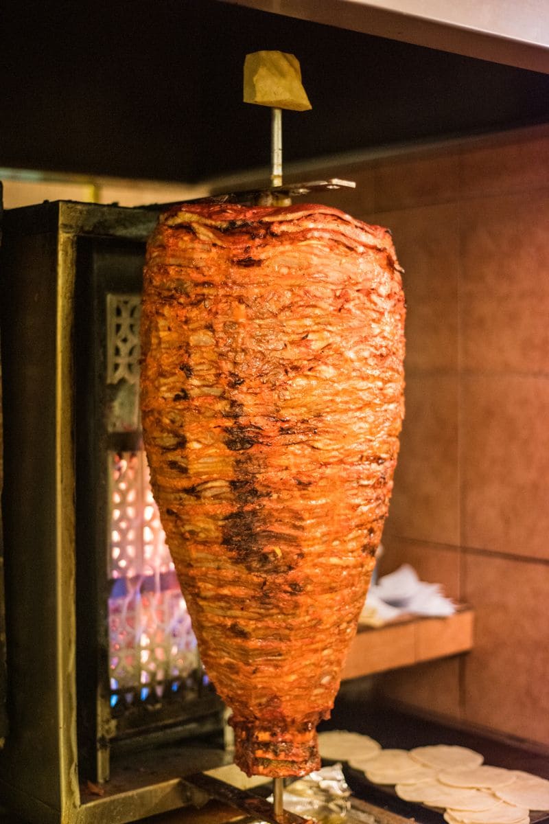 A trompo, a triangle of pork meat marinated and thinly sliced then placed on a skewer and sliced to serve in tacos al pastor