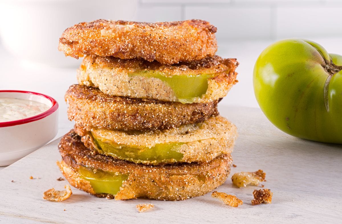 Fried green tomatoes with dipping sauce and fresh tomatoes on the side; copy space 