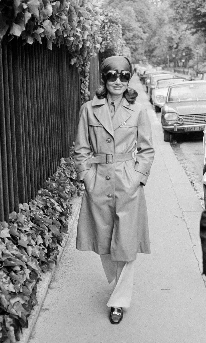 Jackie looked tres chic strolling the streets of Paris in a trench coat, trousers, oversized sunglasses and headscarf.