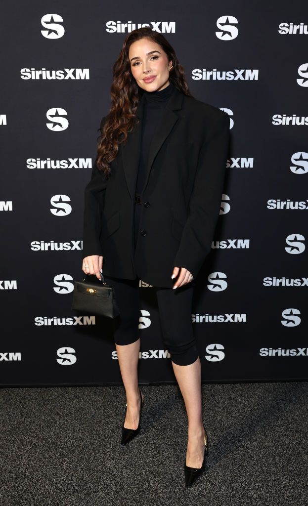 Olivia Culpo poses at a SiriusXM event in an all-black ensemble.