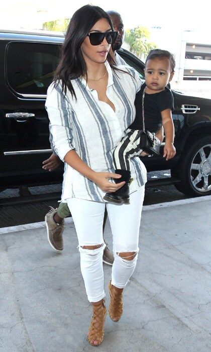 <b>September 2014</b>
<br>
Talk about matching outfits! North complements her mother's striped top with striped pants and a cute crossbody bag. The casual outfit gives us #stylegoals.
</br><br>
Photo: Getty Images