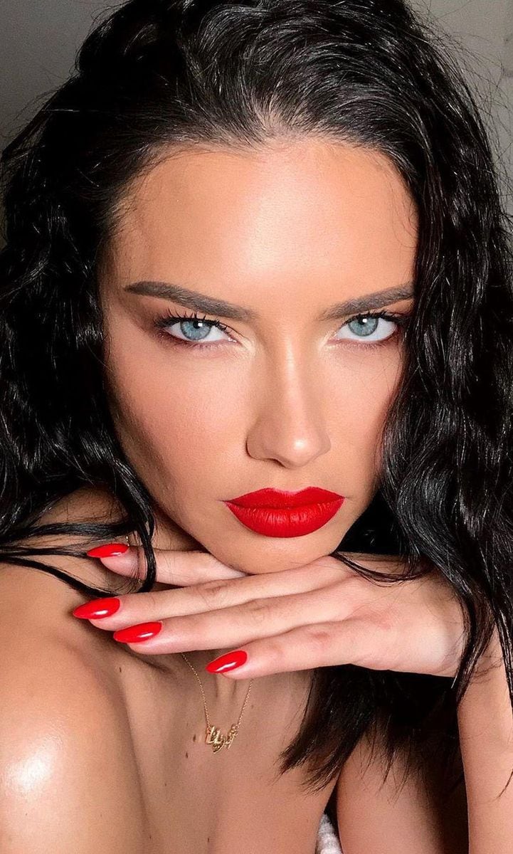 Adriana Lima with makeup showcasing red lips and red nails